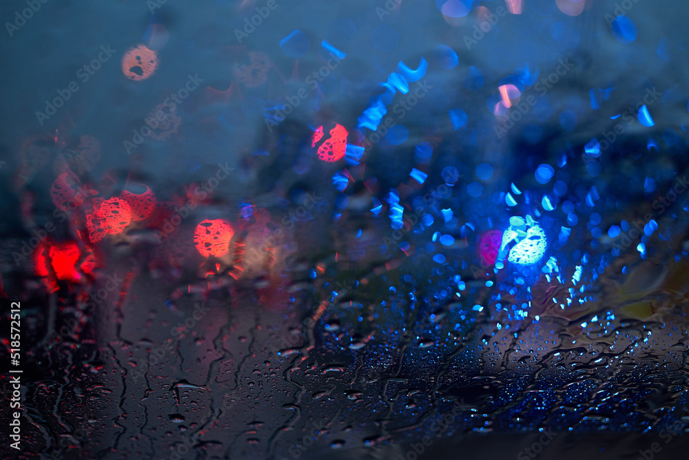 Light of the traffic and car on a rainy night through the windshield Light of the traffic and car on a rainy night through the windshield