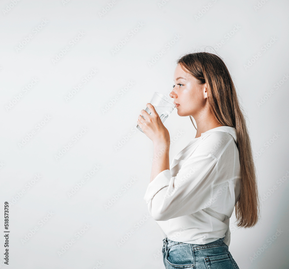 Asian girl with purple drinks water from a plastic bottle on a white isolated background. Generation Z. The concept of thirst Asian girl with purple drinks water from a plastic bottle on a white isolated background. Generation Z. The concept of thirst