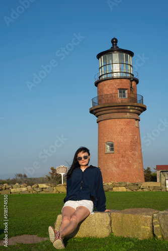 A chinese woman sitting in front of Gayhead lighthouse photo