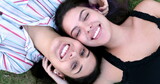 Two lesbian girlfriends lying on grass dating