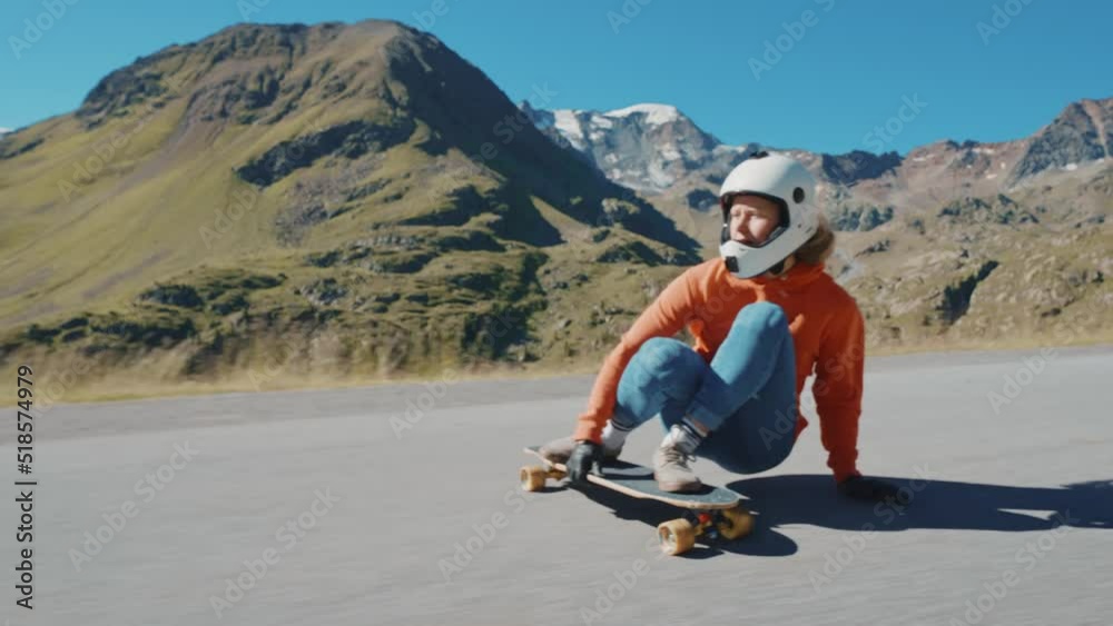 Cinematic downhill longboard session. Young woman skateboarding and making tricks between the curves on a mountain pass. Concept about extreme sports and people Cinematic downhill longboard session. Young woman skateboarding and making tricks between the curves on a mountain pass. Concept about extreme sports and people