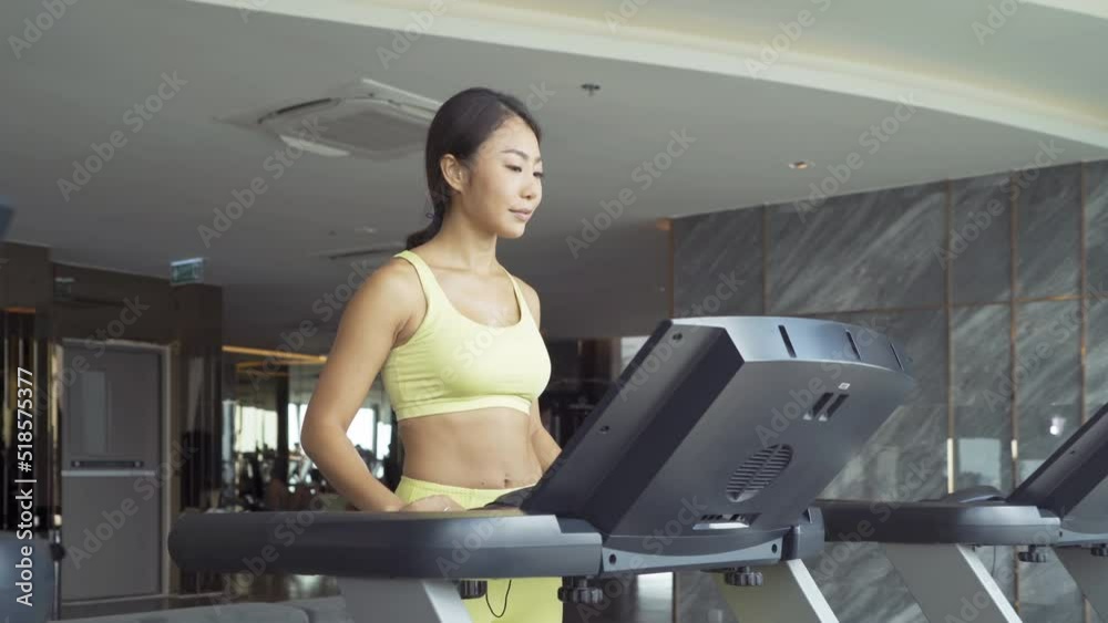 Portrait of fit healthy Asian woman, person, running or jogging on treadmill, and training in gym or fitness center in sport and recreation concept. Lifestyle activity. Portrait of fit healthy Asian woman, person, running or jogging on treadmill, and training in gym or fitness center in sport and recreation concept. Lifestyle activity.