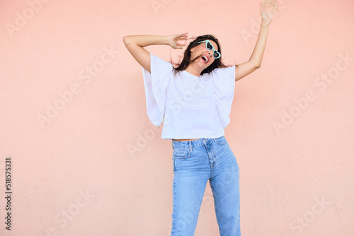 happy young woman posing in a fun way with heart shaped sunglasses 