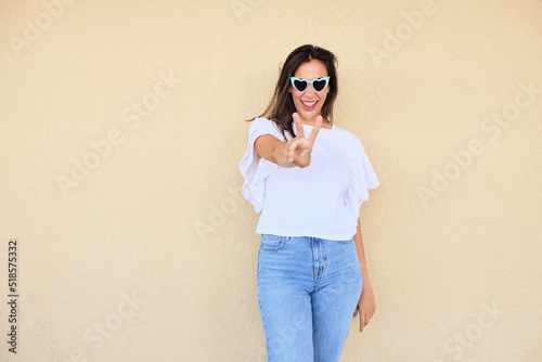 happy young woman posing in a fun way with heart shaped sunglasses 