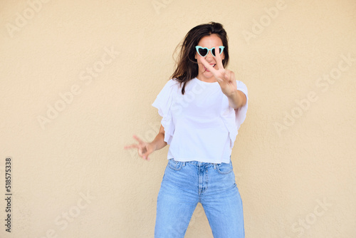 happy young woman posing in a fun way with heart shaped sunglasses 