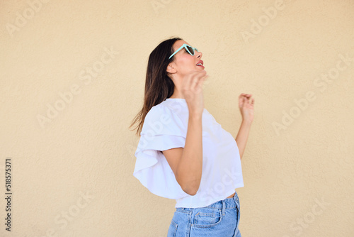 happy young woman posing in a fun way with heart shaped sunglasses 