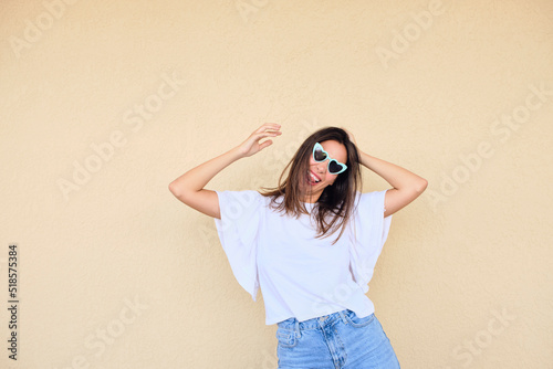 happy young woman posing in a fun way with heart shaped sunglasses 