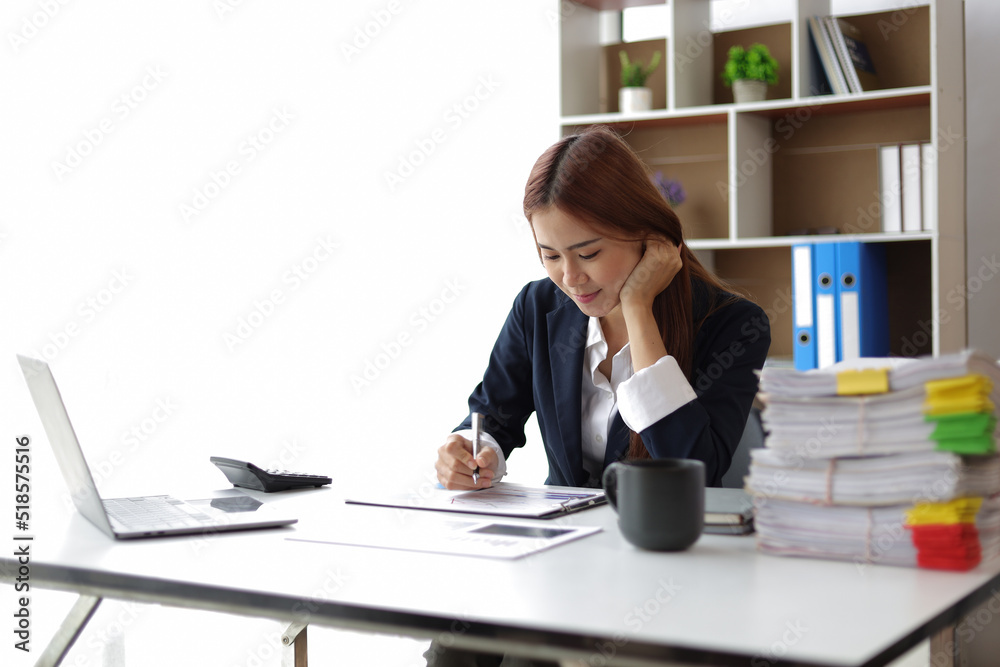 Attractive Asian businesswoman in office working on financial documents. Attractive Asian businesswoman in office working on financial documents.