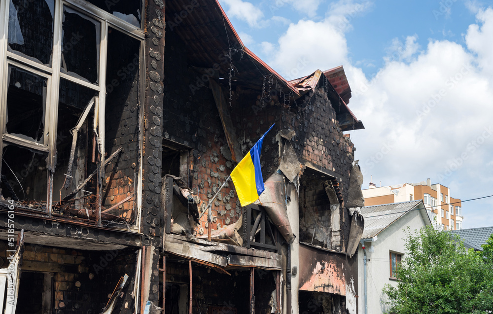 House with Ukrainian flag destroyed by russian weapons. Atrocities of the russian army in the suburbs of Kyiv (Irpin). russia's war against Ukraine.