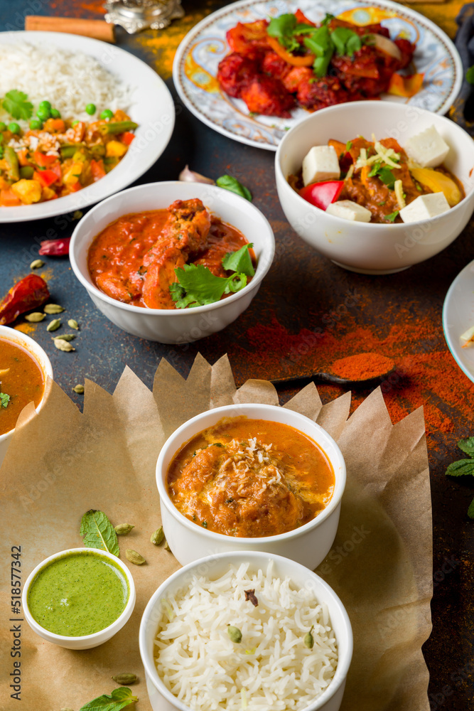 chicken tikka masala, kadai chicken; coconut sabdji, indias samosa, veg curry;bainkar bharta, Indian food on dark blue stone background with spices vertical chicken tikka masala, kadai chicken; coconut sabdji, indias samosa, veg curry;bainkar bharta, Indian food on dark blue stone background with spices vertical
