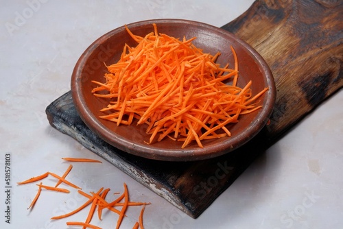 grated carrot in a bowl on white background 