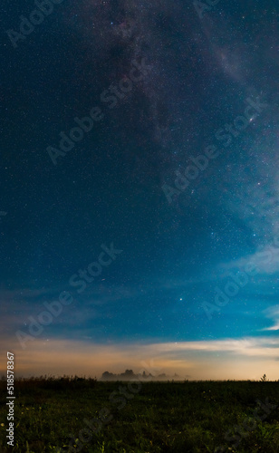 A natural landscape at night. The Milky Way galaxy, many stars, and the Andromeda galaxy above the fog field at midnight