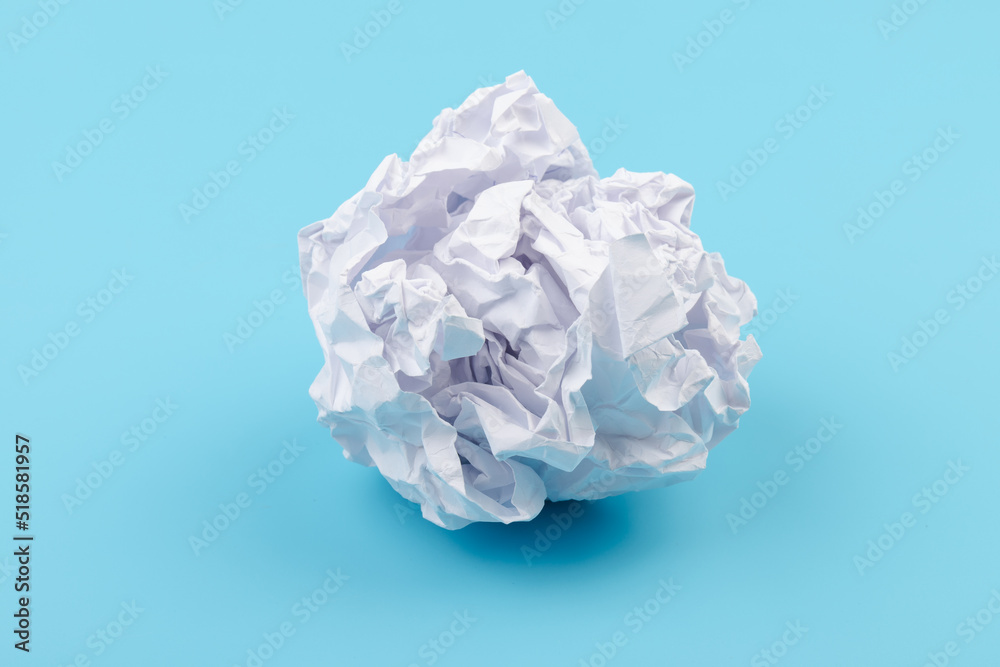 A piece of crumpled white paper on a blue background.