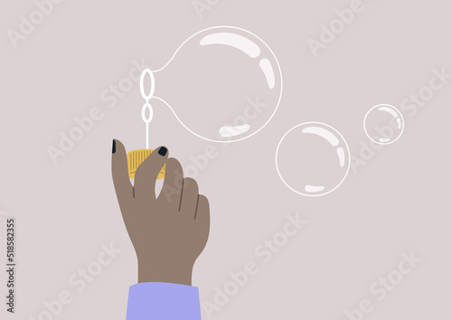 A hand holding a soap bubble blower