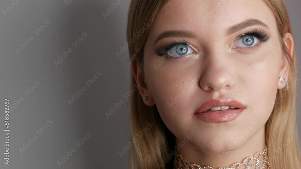 Portrait of a beautiful young girl model in stylish evening make up smoky eyes with beautiful golden eyeshadow and delicate lipstick on the lips. Eyes close up view Portrait of a beautiful young girl model in stylish evening make up smoky eyes with beautiful golden eyeshadow and delicate lipstick on the lips. Eyes close up view