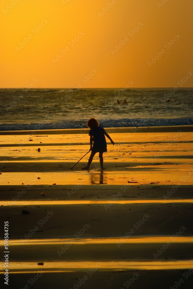 silhouette of a little girl on the beach when sunset