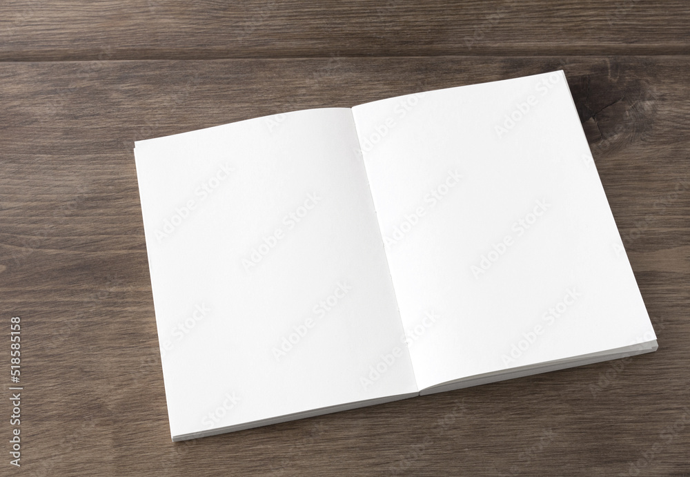 Blank white spread notebook on the desk from an oblique angle Blank white spread notebook on the desk from an oblique angle