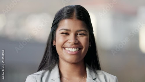 Closeup portrait of a real estate agent smiling and looking cheerful while standing against a blurred background. The face of one young realtor laughing while selling houses photo