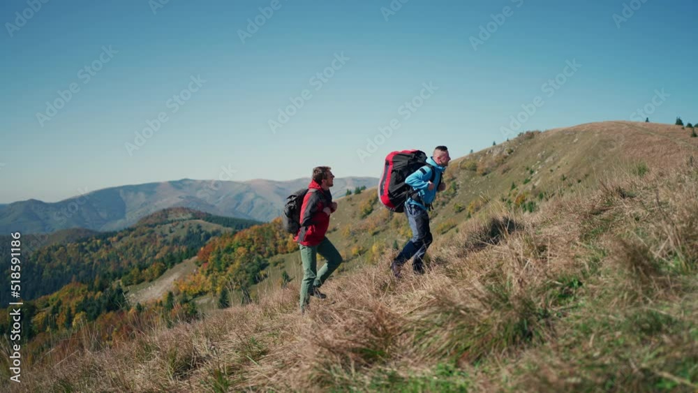 Paragliders, trekkers, mountaineers, walking up hill to a paragliding starting point, on a sunny morning in mountains. Paragliders, trekkers, mountaineers, walking up hill to a paragliding starting point, on a sunny morning in mountains.