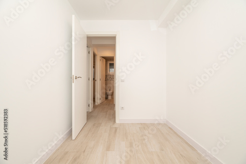Empty room with light wood flooring  off-white painted walls and white woodwork