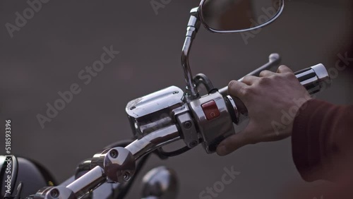 the biker turns on the ignition button and starts engine of retro motorcycle. rotate the throttle handle several times