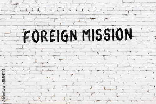 Night view of neon sign on brick wall with inscription foreign mission