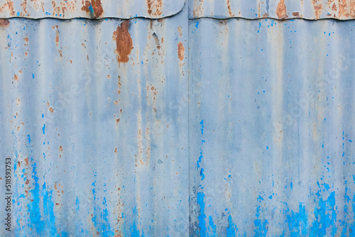 Corrugated metal in blue paint texture old fence background weathered obsolete © Andrey