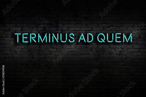 Night view of neon sign on brick wall with inscription terminus ad quem photo