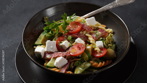 Italian pasta salad cucumbers, cherry tomatoes, olives, red onion, salami, feta cheese, and Rotini