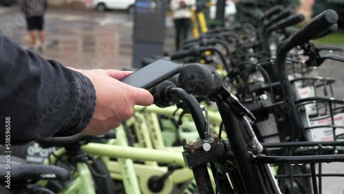 Electric scooter or bicycle in a shared parking lot, an application for a tourist phone. Alternative means of transportation using eco-transport photo