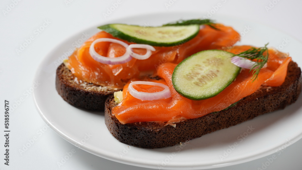 Danish open sandwich Smorrebrod on dark rye bread with herring, salmon, beetroot, red onions, and radish