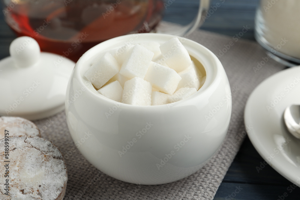 Refined sugar cubes in ceramic bowl on table Refined sugar cubes in ceramic bowl on table