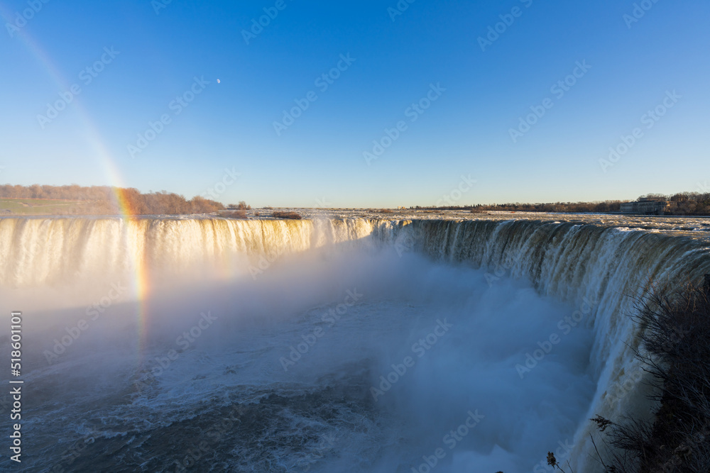 Horseshoe Falls in a sunny day with rainbow. Niagara Falls, Ontario, Canada. Horseshoe Falls in a sunny day with rainbow. Niagara Falls, Ontario, Canada.