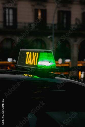 Luz de taxi iluminada noche color verde disponible con luces de ciudad de fondo