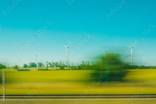 Beautiful view from a car of agricultural fields with windmills photo