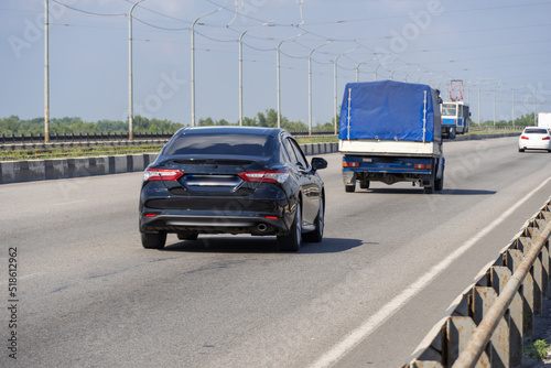 Transport on the road bridge in summer day. Panorama on bridge for truck and car and tram passenger transport. Tramline. Infrastructure Dnipro Ukraine. Speed ​​limit. © IhorStore