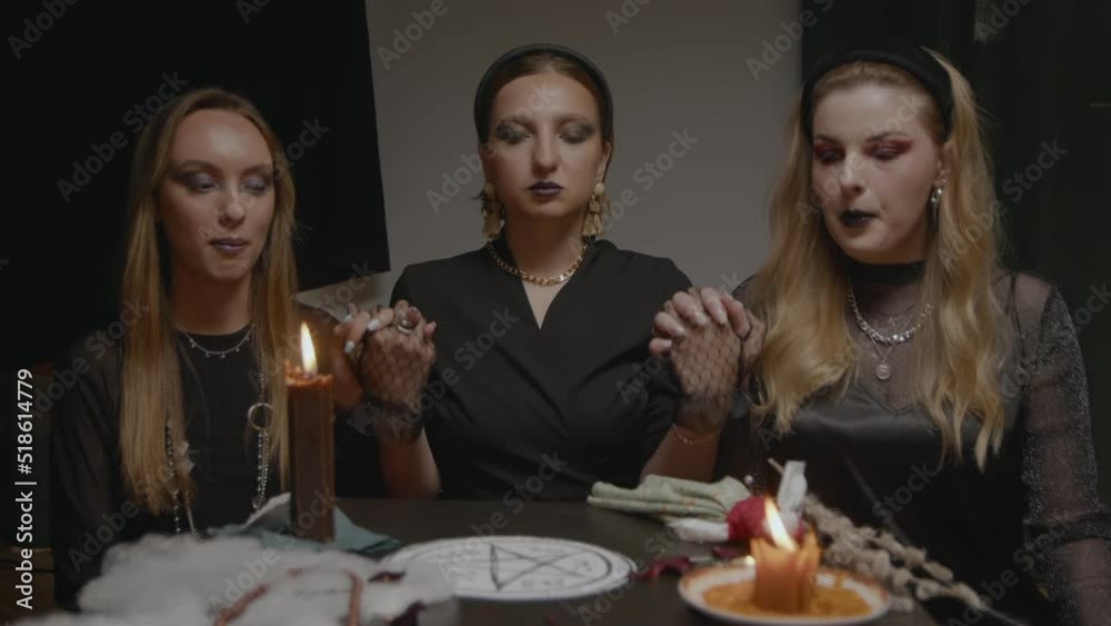 4K. Three female witches in a dark room conduct mystical sessions 4K. Three female witches in a dark room conduct mystical sessions