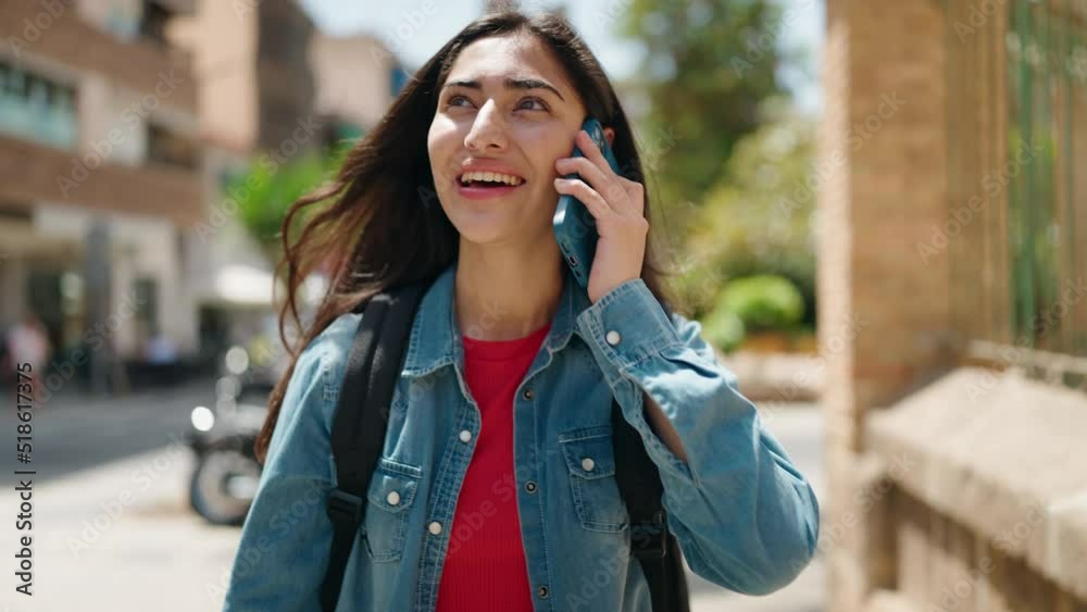 Young hispanic girl student talking on the smartphone walking at street Young hispanic girl student talking on the smartphone walking at street