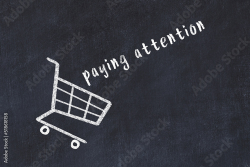 Photography Chalk drawing of shopping cart and word paying attention on black chalboard