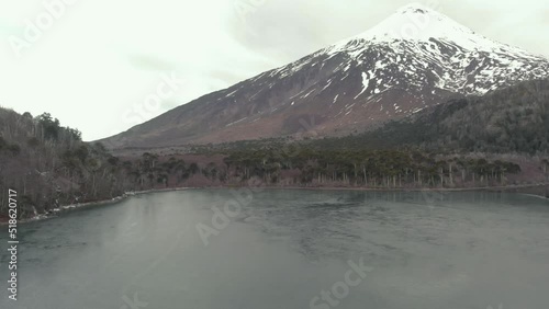 Beautiful view of Quetrupillan volcano in Villarrica National Park surrounded by trees and laguna photo