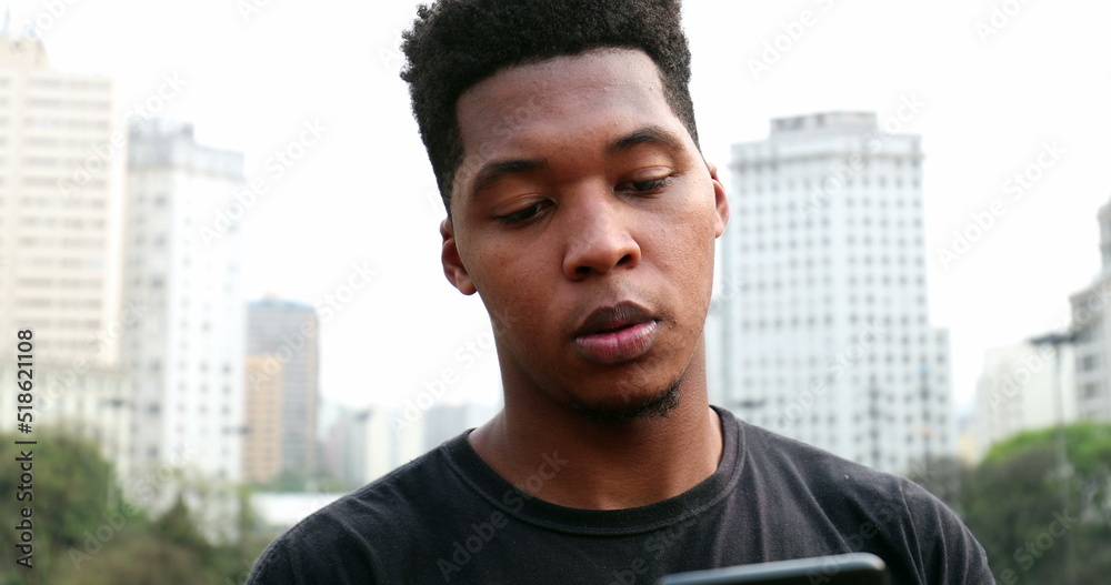 African black man using cellphone in street African black man using cellphone in street