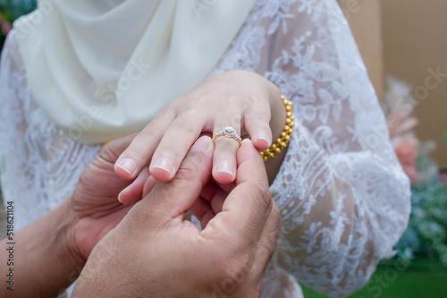 Canvas Print muslim groom wearing wedding rings to left ring finger of muslim bride