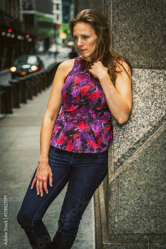 Obraz na płótnie Thinking Outside. Young woman with damp hair, wearing purple pattern top, blue jeans, leaning against column on street in New York City, into deeply thinking.. w salonie