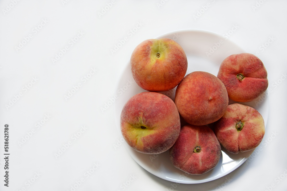 Juicy red and yellow peaches on a white plate. Delicious peaches for lunch. Juicy red and yellow peaches on a white plate. Delicious peaches for lunch.