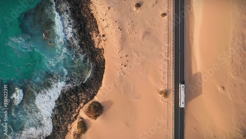 Aerial of famous scenic road in desert sand dunes along ocean coast at Fuerteventura, Canary Islands, Spain. Corralejo Dunes Natural Park top down drone view from above. 