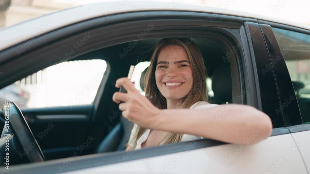 Young woman smiling confident holding key of new car at street Young woman smiling confident holding key of new car at street