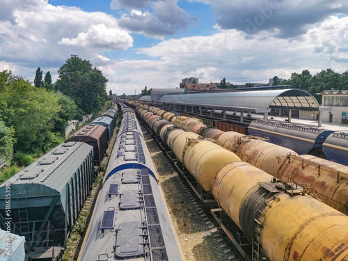 Cargo Trains and Containers at a Terminal. Train wagons carrying cargo containers for shipping companies. Distribution and freight transportation using railroads.