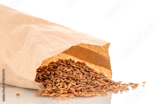 Organic uncooked brown rice in a paper bag, close-up, isolated on white background.
