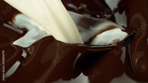 Close-up of pouring stream of melted chocolate and milk.