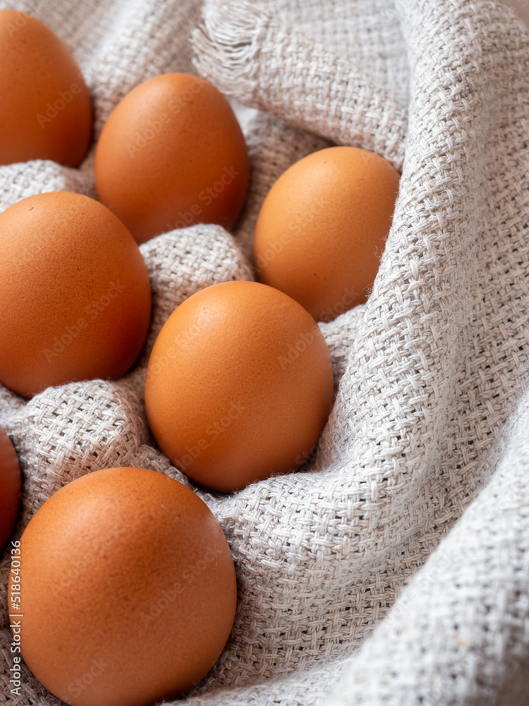 group of brown chicken eggs on a grey table linen cloth group of brown chicken eggs on a grey table linen cloth